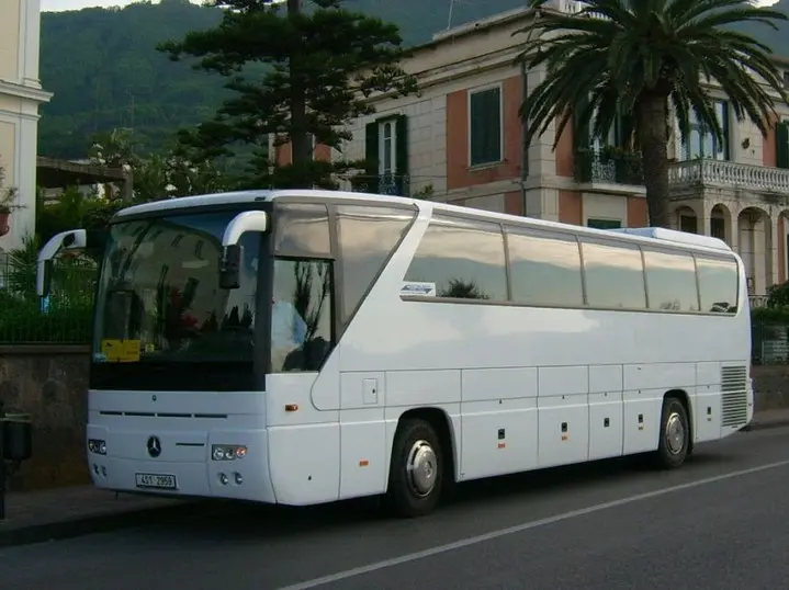 Bílý zájezdový autokar při zahraniční cestě