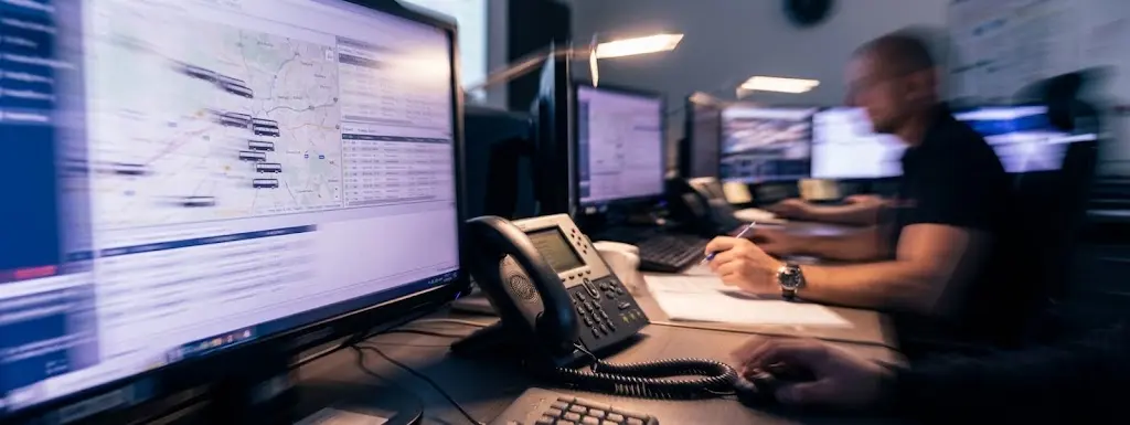 Dispečer autobusové dopravy u telefonního a monitorovacího pracoviště